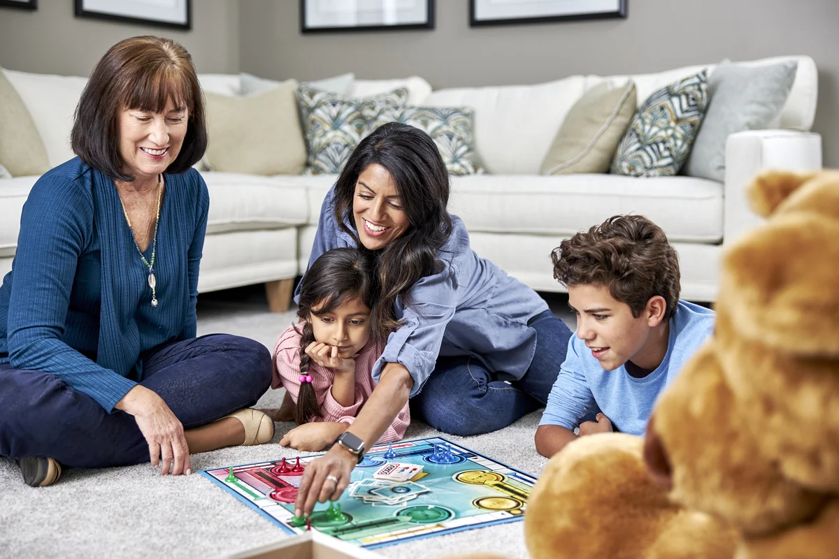 Family playing board game on clean carpet